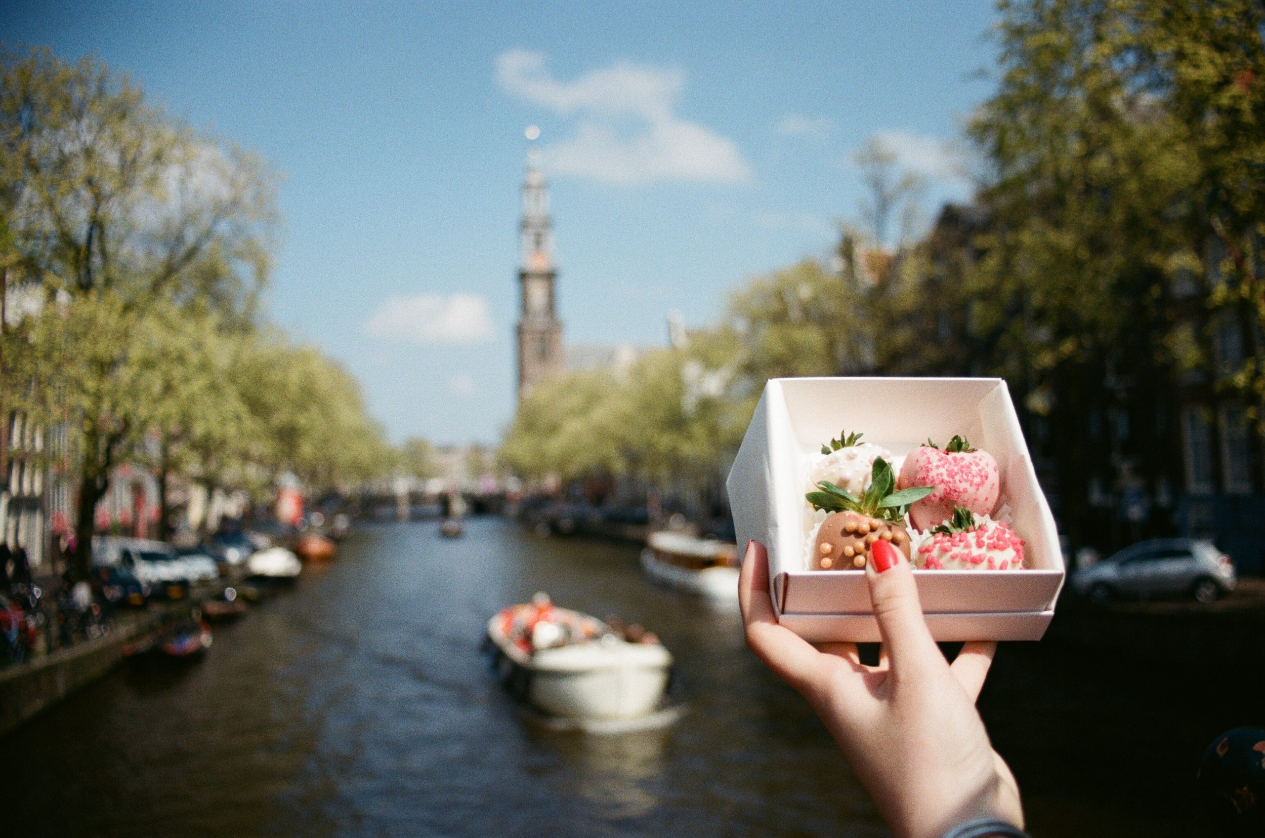 Eating some delicious sweets while looking at Amsterdam Canal - 10 Reasons To Visit Amsterdam 