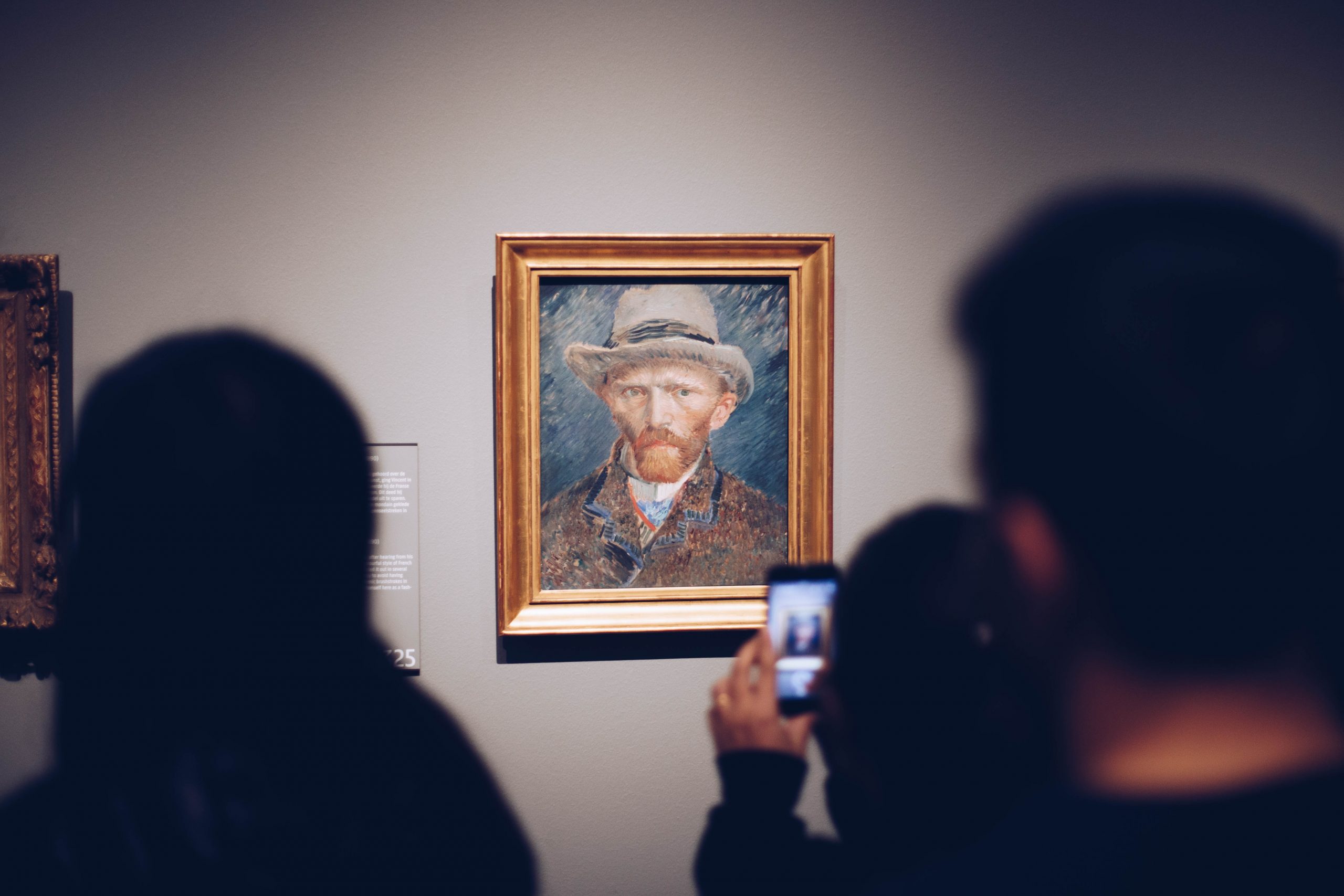 People passing by Vincent van Gogh’s self portrait and snapping a photo at Rijksmuseum