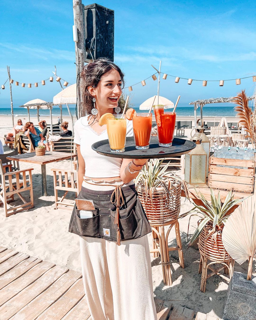 Girl serving delicious and colorful cocktails at Hippie Fish - Best Exotic Beach Clubs in Europe