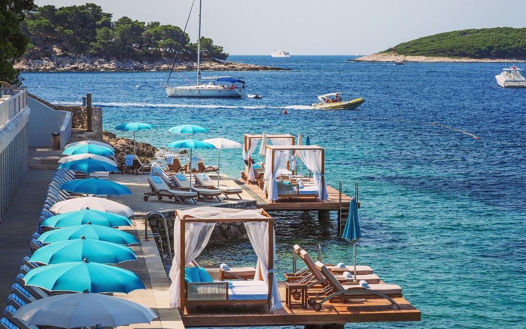 Amazing setting of blue umbrellas, chaise longue chairs and canopies at Beach Club Hvar