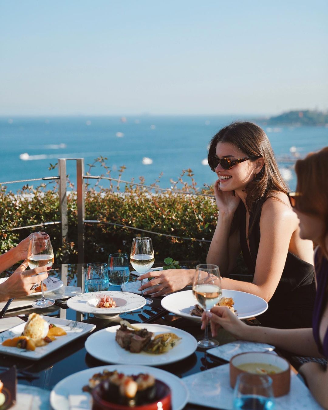 Beautiful girl enjoying her meal and the incredible Bosphorus views with her friends at 16 ROOG Istanbul
