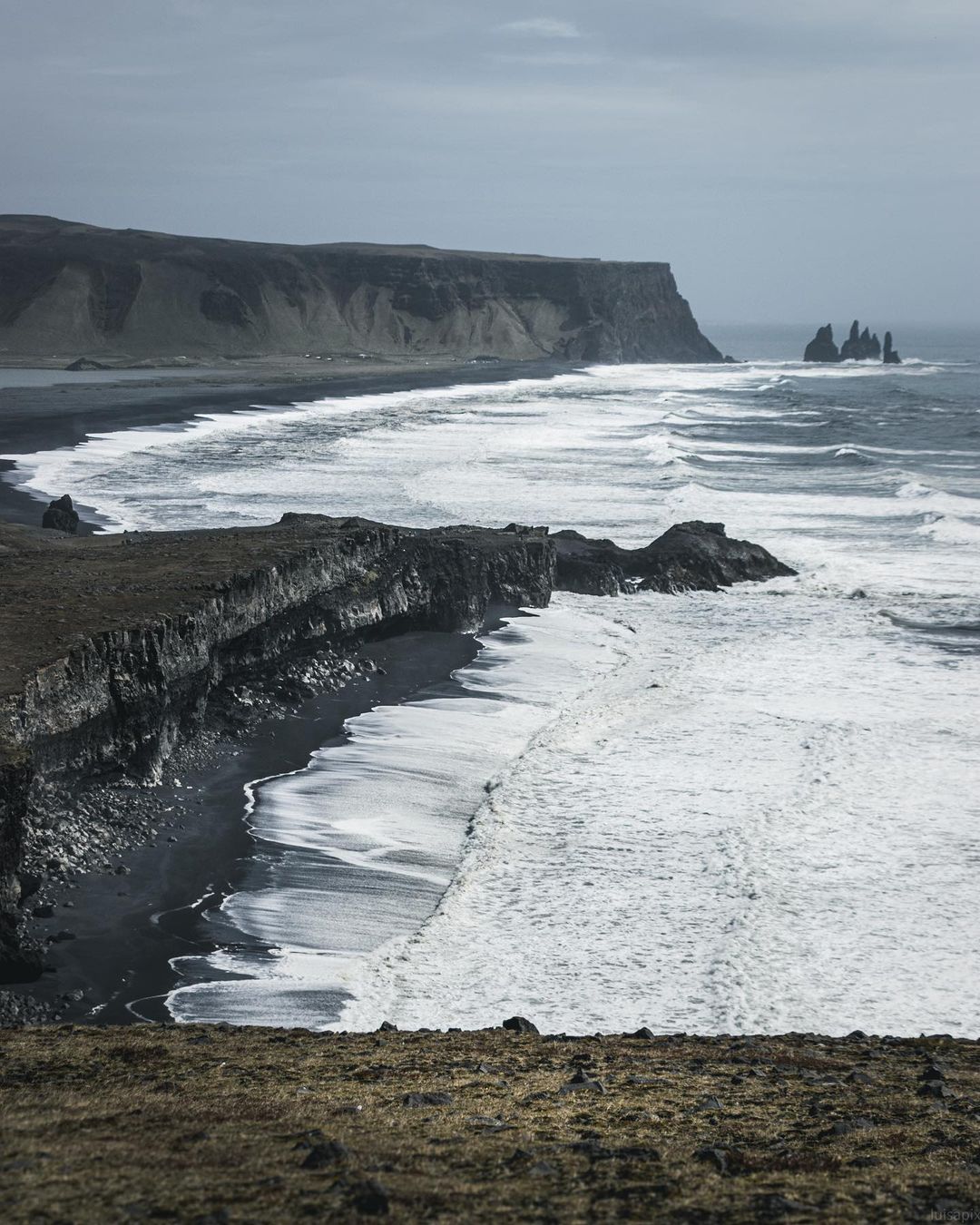 Reynisdrangar sea stacks and basalt columns at Reynisfjara black sand beach in winter near Vík í Mýrdal